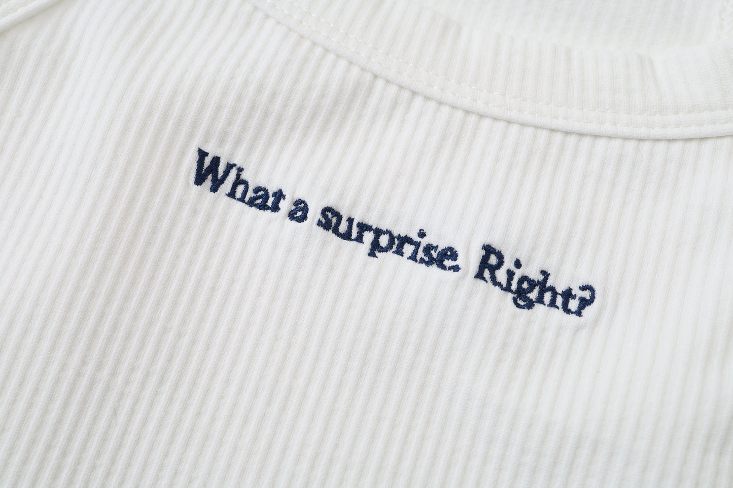 Top Blanco de algodón 100% con frase en inglés: "What a surprise. Right?"